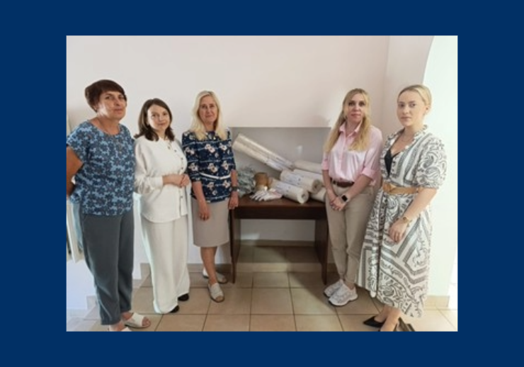 Fünf Frauen vor eine Box mit Hilfesmitteln zur Restaurierung von Archivgut.