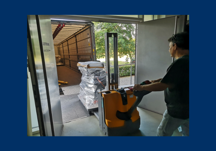 Man beim Einladen von Palette mit HIlfsmitteln zur Restaurierung auf einen LKW.