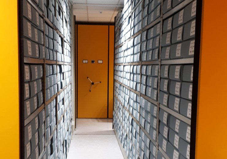 Gelbe Drehregalen im Magazin des Kreisarchivs, gefüllt mit grauen Archivkartons.