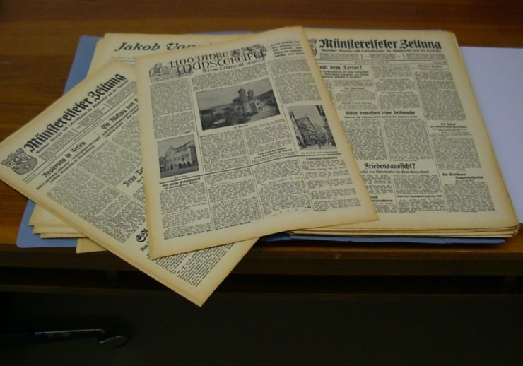 Ein Tisch mit vier alten Zeitungen